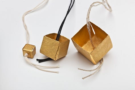 silver and gold boxes hung on string