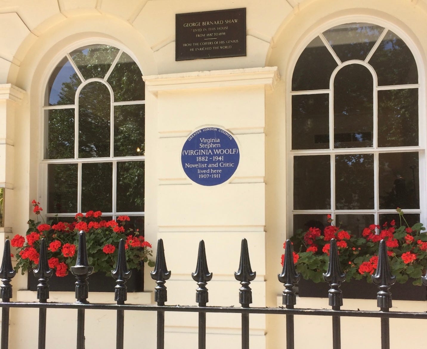 A house facade in a London square with two arched windows and a blue plaque for Virginia Woolf and another plaque for George Bernard Shaw.