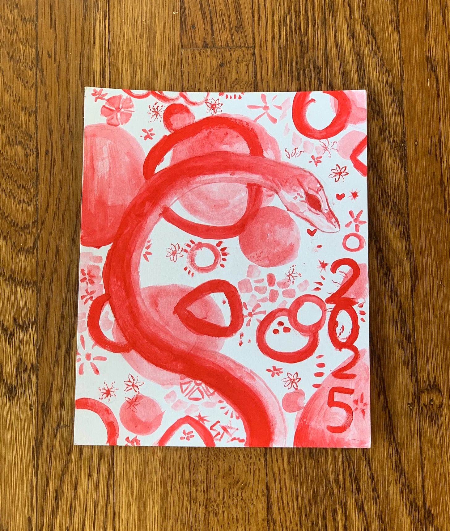 Red and white painting of snake with decorations and "2025" Red and white painting of snake with decorations and "2025"
