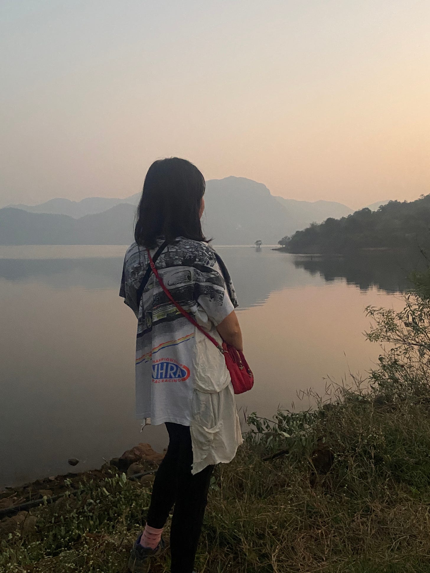 photo of author looking out at a lake at sunset