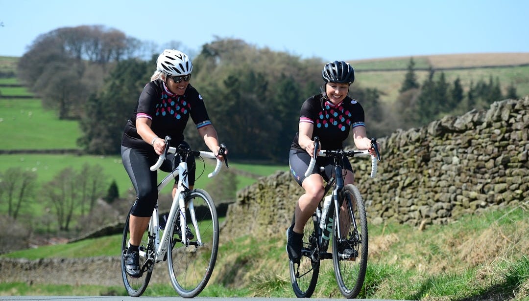 a couple of people riding bikes down a road