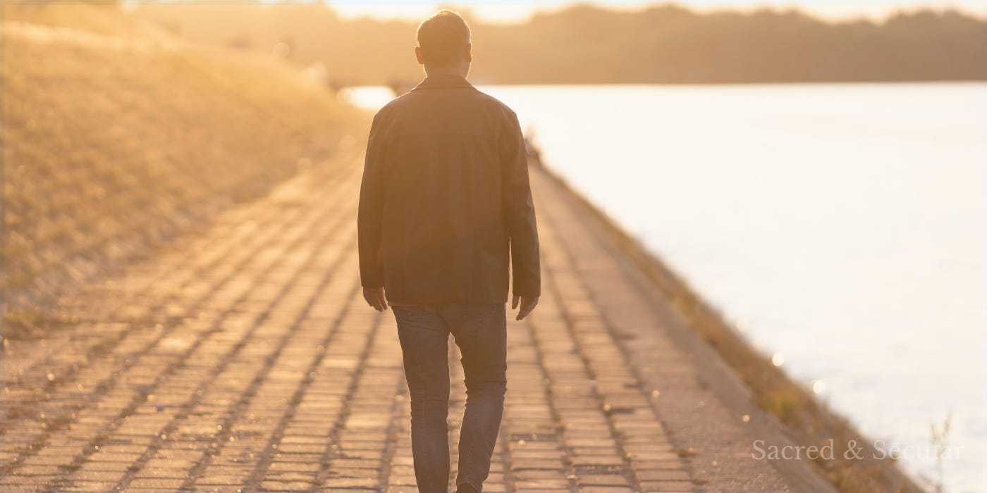 A lone person walks along a sunlit waterside path at golden hour, viewed from behind. Long shadows stretch across the paving, creating a reflective scene that suggests a quiet journey, difficult choices, and moving towards the light. A lone person walks along a sunlit waterside path at golden hour, viewed from behind. Long shadows stretch across the paving, creating a reflective scene that suggests a quiet journey, difficult choices, and moving towards the light.