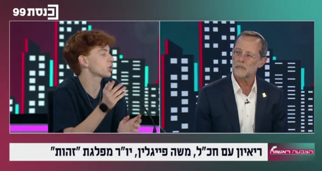 Captura de pantalla de una entrevista en la televisión israelí en la que Eitan Newman, a la izquierda, habla y gesticula, mientras Moshe Feiglin, vestido con traje oscuro y gafas, lo escucha a la derecha. El fondo de pantalla dividida muestra una ciudad estilizada, con rótulos en hebreo que identifican la entrevista y el canal.