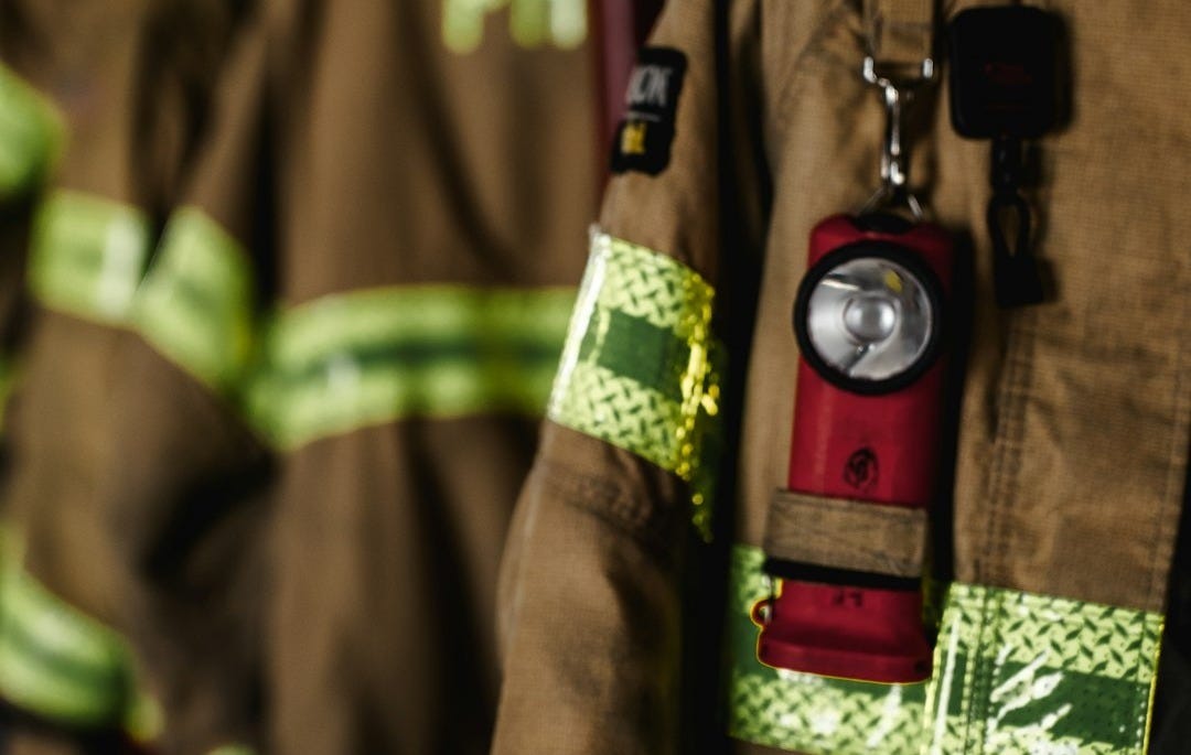 a fireman's uniform hanging on a rack a fireman's uniform hanging on a rack