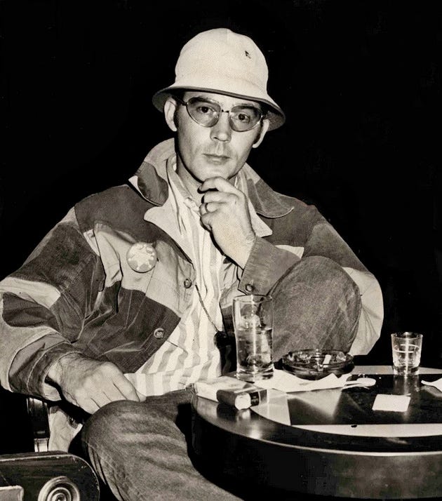 Phtot shows Hunter S. Thompson, right hand stroiking his chin.