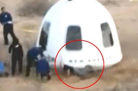 bezos falling down in front of space capsule