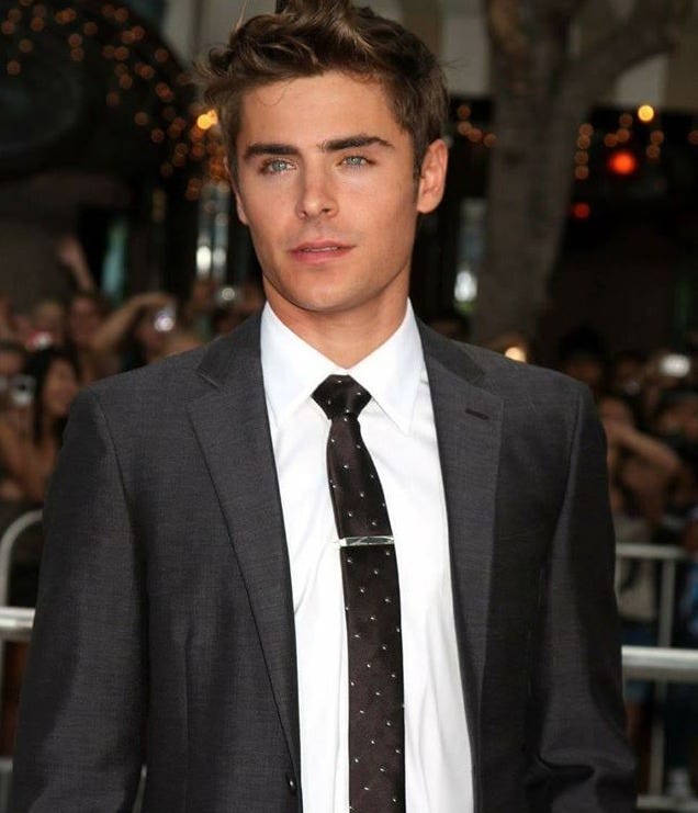 This may contain: a young man in a suit and tie