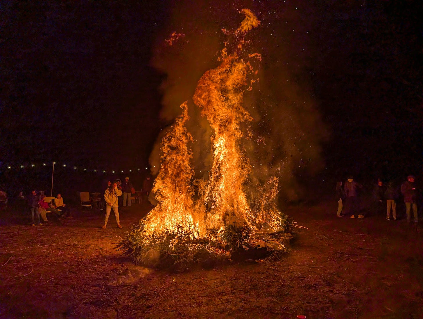 A nightime bonfire, with flames reaching into the sky