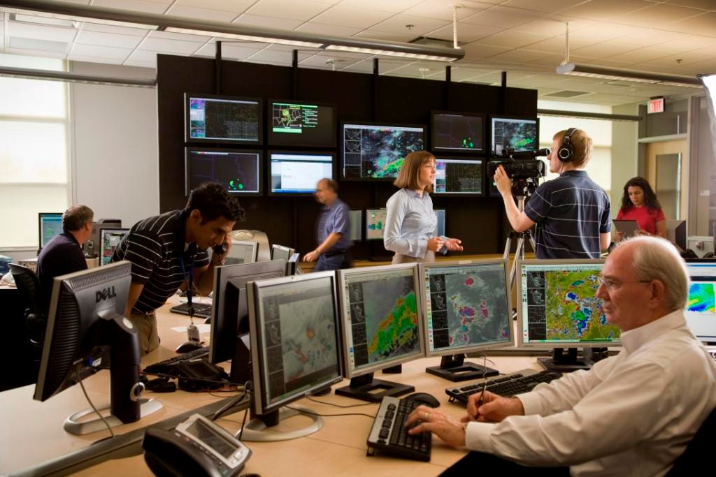 Meteorologists in a weather forecast office generate forecasts, answer phones, speak to media, and assess weather conditions.