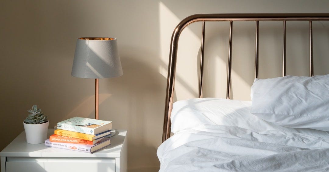 table lamp on white wooden nightstand beside bed