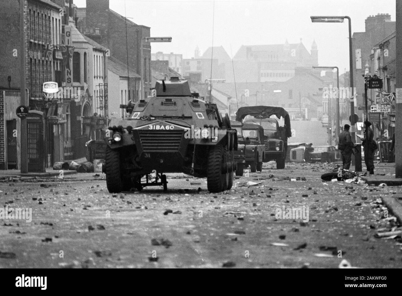 Armoured cars rumble over the rubble past overturned cars and a wrecked ...