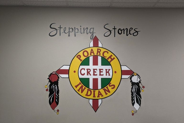 A colorful sign is painted on an interior wall that reads "Stepping Stones" and "Poarch Creek Indians". A colorful sign is painted on an interior wall that reads "Stepping Stones" and "Poarch Creek Indians".