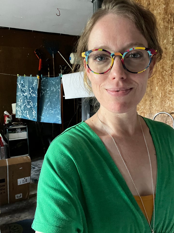 Left: a colorful pant leg and foot show in front a fire in a stone firepit surrounded by green grass. Right: the artist looks into the camera while prints are drying on a clothesline behind her.