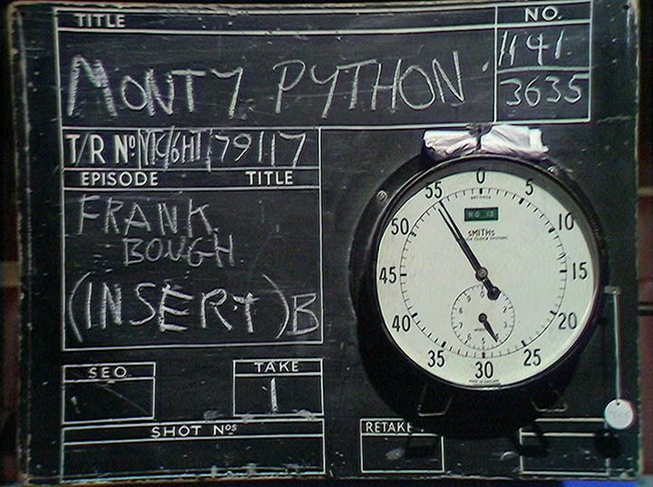 A chalkboard VT clock, followed by Michael Palin as Frank Bough looking very amused at Eric Idle's dirty joke