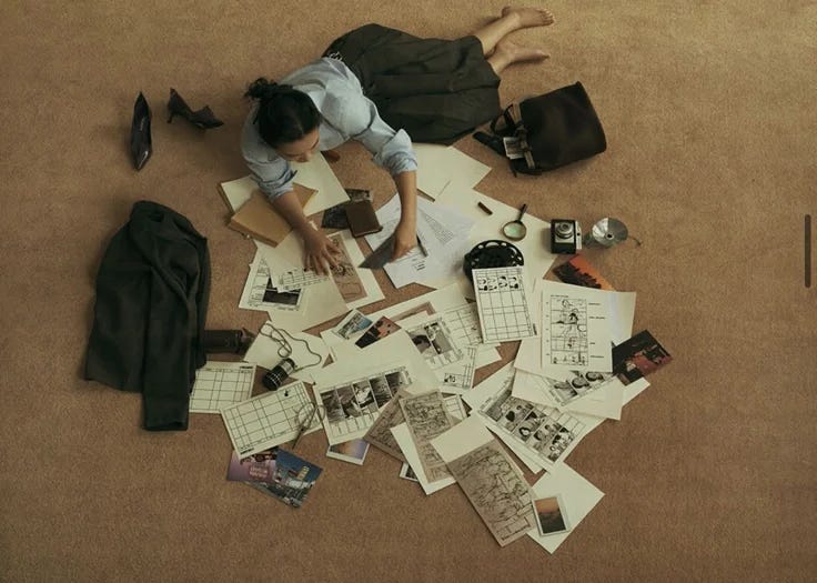 This may contain: a woman is laying on the floor surrounded by papers and other items that are scattered around her