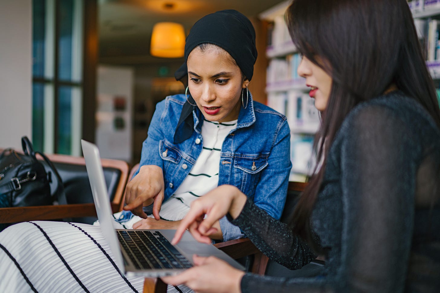 Two women discussing something on a laptop. Two women discussing something on a laptop.