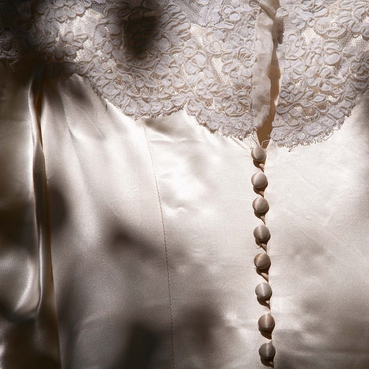 Diptych of wedding dress - in a box on the left, a row of satin covered buttons in shadows on the right.