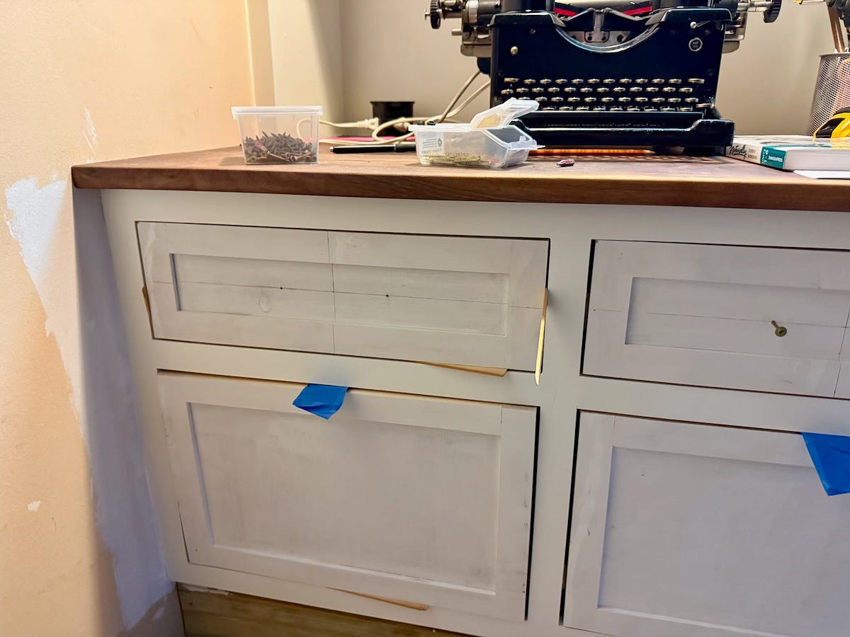 Drawer fronts in the process of being installed in a built-in cabinet.