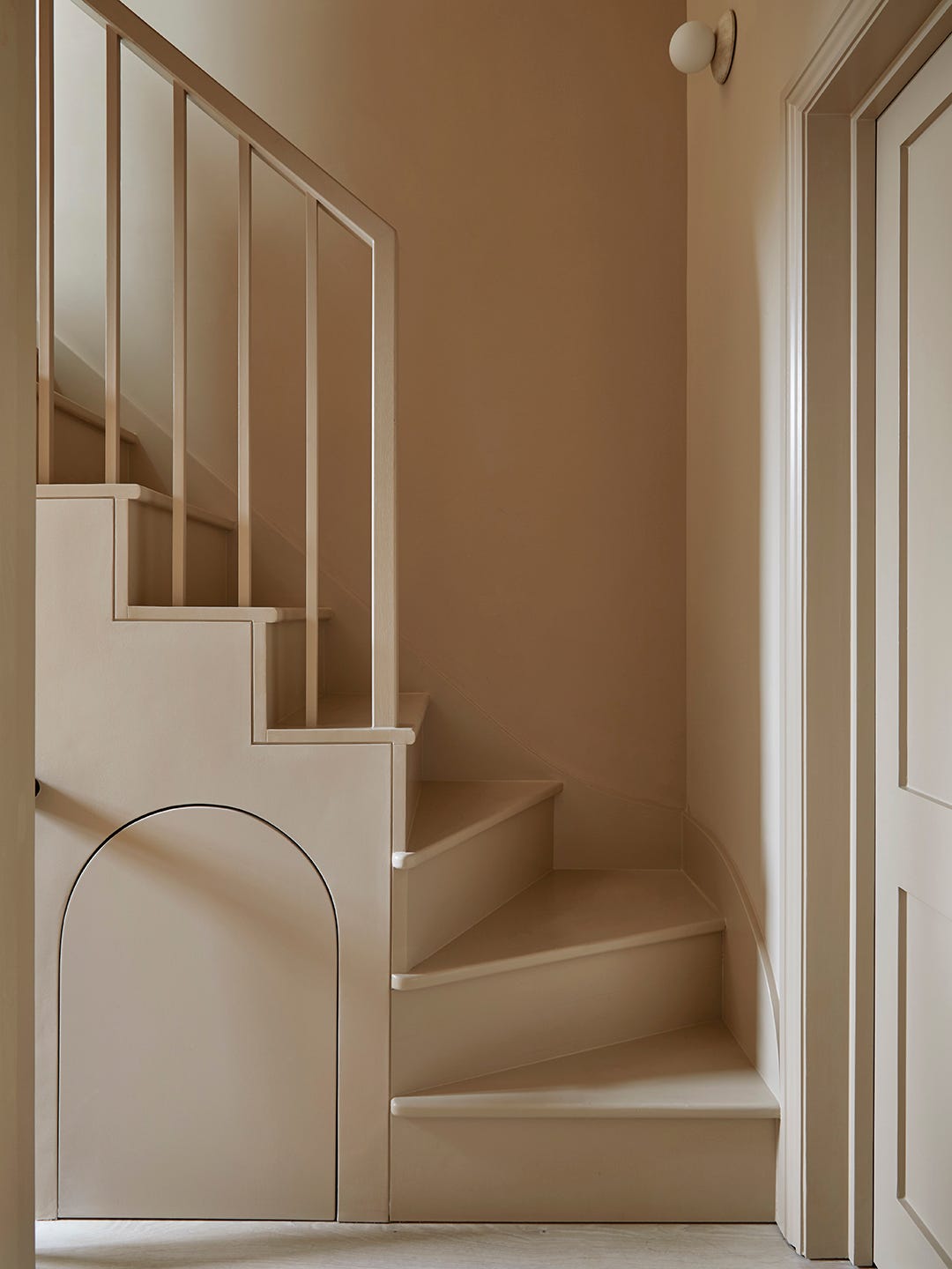 A neutral staircase that winds around a tight corner