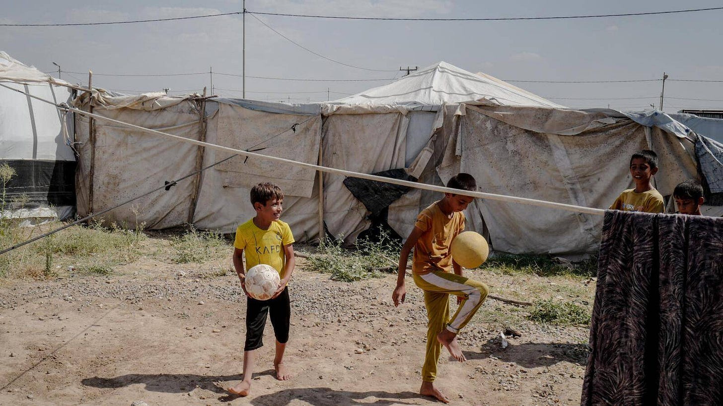 Deux orphelins, fils d’anciens combattants, jouent au football entre les tentes du camp.  — © Lucas Barioulet