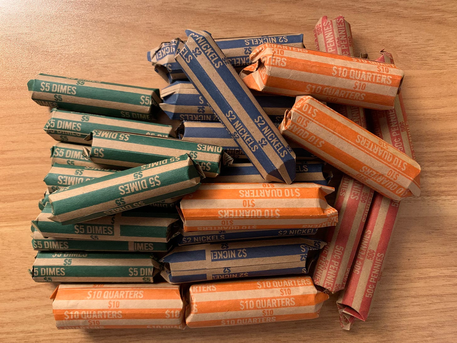 Rolls of coins—including quarters, dimes, nickels, and pennies—totaling over $100.