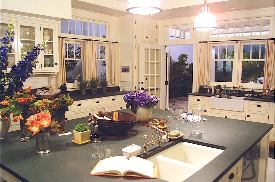 Something's Gotta Give kitchen in a Hamptons beach house with its white Shaker cabinets, black soapstone counters, stainless appliances, subway tile and classic coastal style! Get ideas for your own kitchen in this kitchen inspiration post! #kitchendesign #somethingsgottagive #kitchendecor #interiordesignideas #traditionalstyle #hamptons #beachhouse