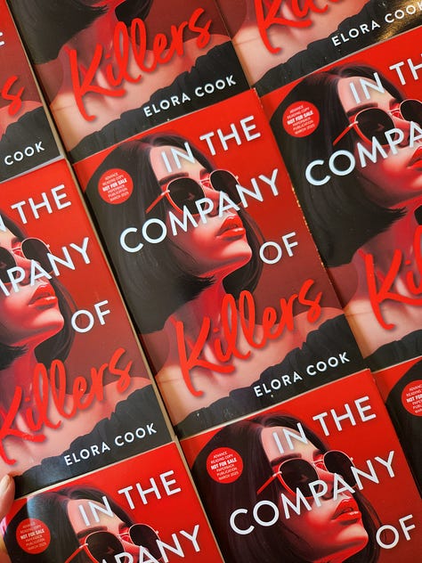 Photos of Elora holding an advanced copy of In the Company of Killers and one flatlay photo of all her advanced copies of the book.