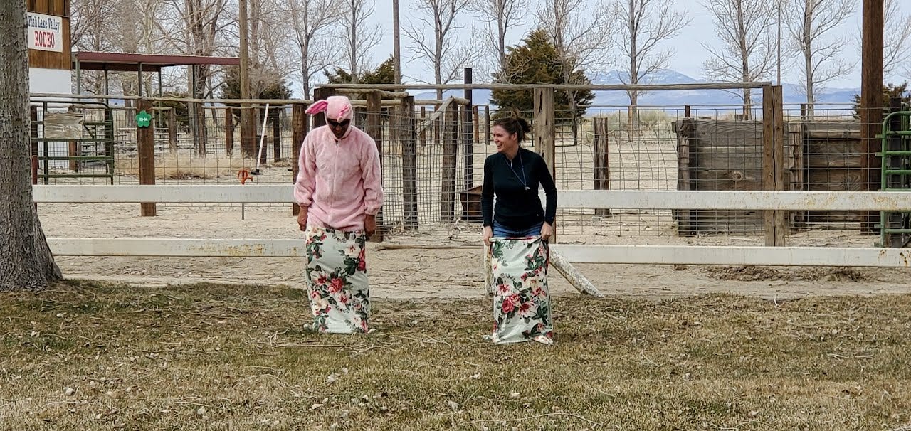 Eric in a pink bunny suit and Charlotte next to him. Both are in pillowcases for a sac rack and about to start jumping.