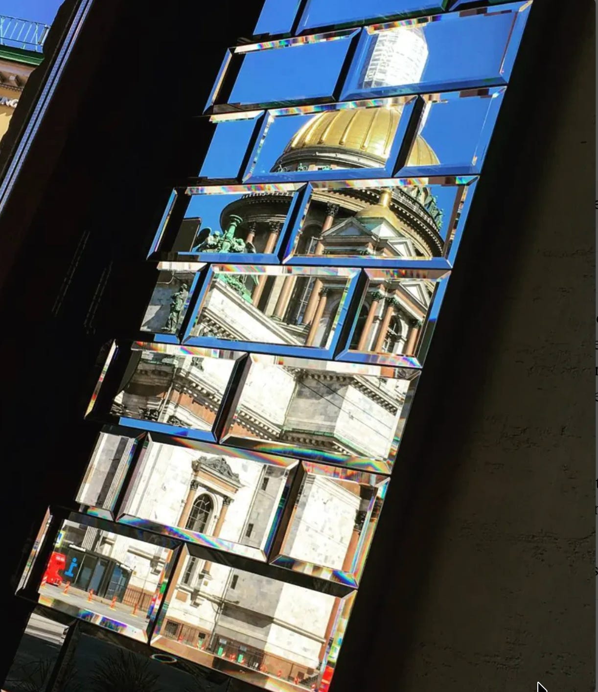A geometric reflection of St. Isaac's golden dome and classical architecture broken into angular segments through mirrored panels, each showing a different fragment of the building.