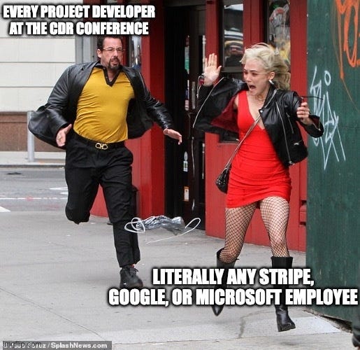 Adam Sandler in a gold shirt running down a street after a woman in a red dress who is running away. He is labelled "Every project developer at the CDR conference," she is labelled "Literally any Stripe, Google, or Microsoft employee."