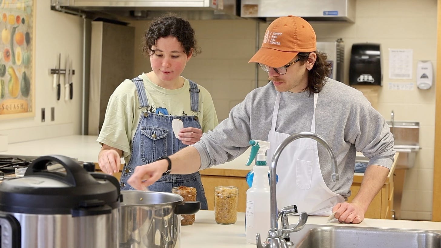 A person and person cooking in a kitchen

Description automatically generated