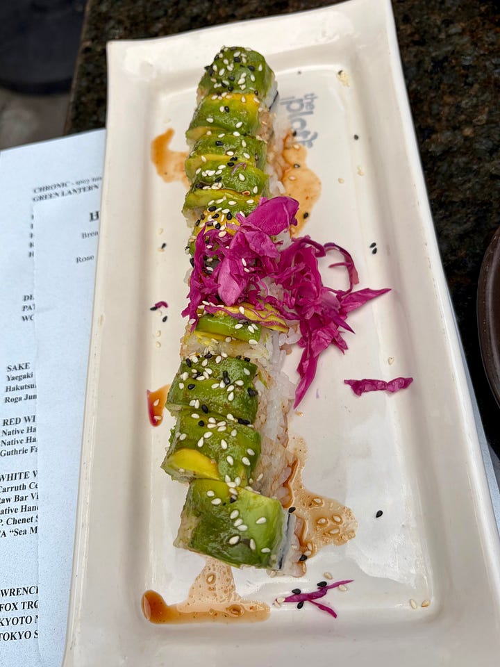 Left: a hand with red nail polish holding a glass of golden IPA with a thick foam head. Right: a close-up of the Patrick the Great roll, crispy sweet potato topped with sesame seeds, avocado, and pickled purple cabbage.
