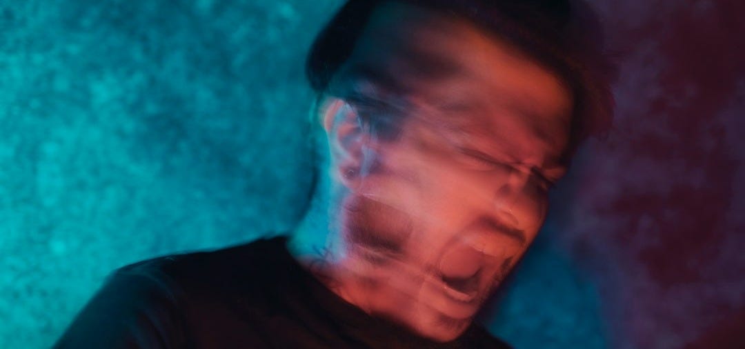 a man in a dark room with his eyes closed