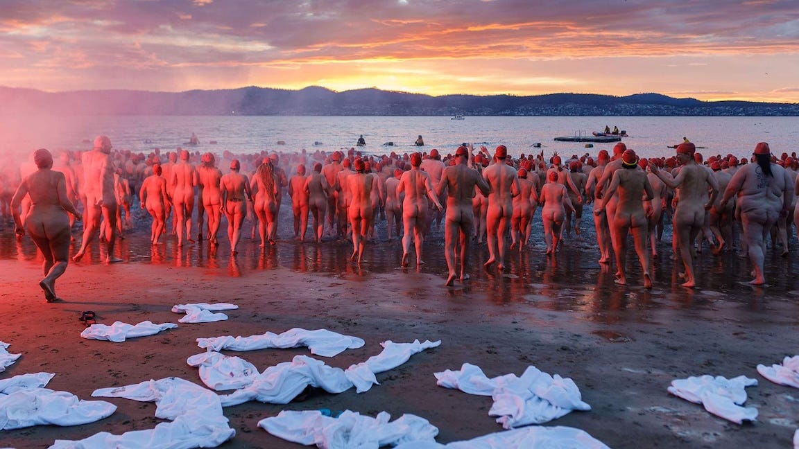 3,000 nude swimmers in red swimcaps walk into the sea