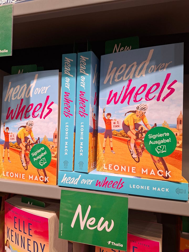 The author signing copies of Head Over Wheels and the books sitting on the shelves