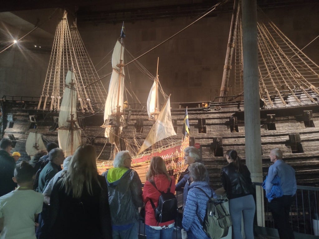 A smaller model (10ft or so) of the ship stands in front of it