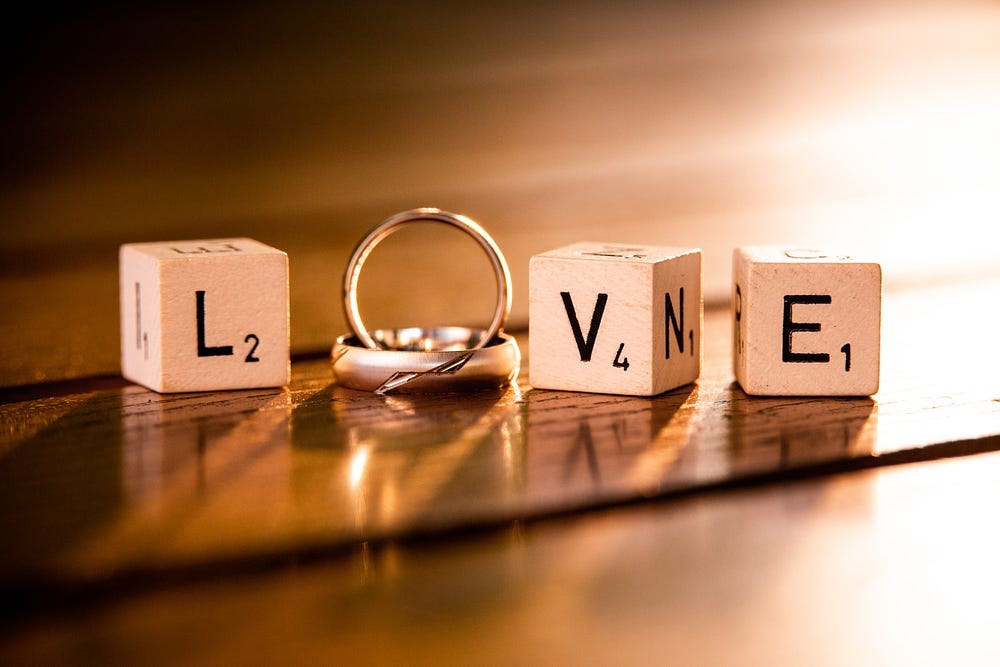 The word ‘Love’ spelled out by scrabble blocks, with a wedding ring forming the letter O.
