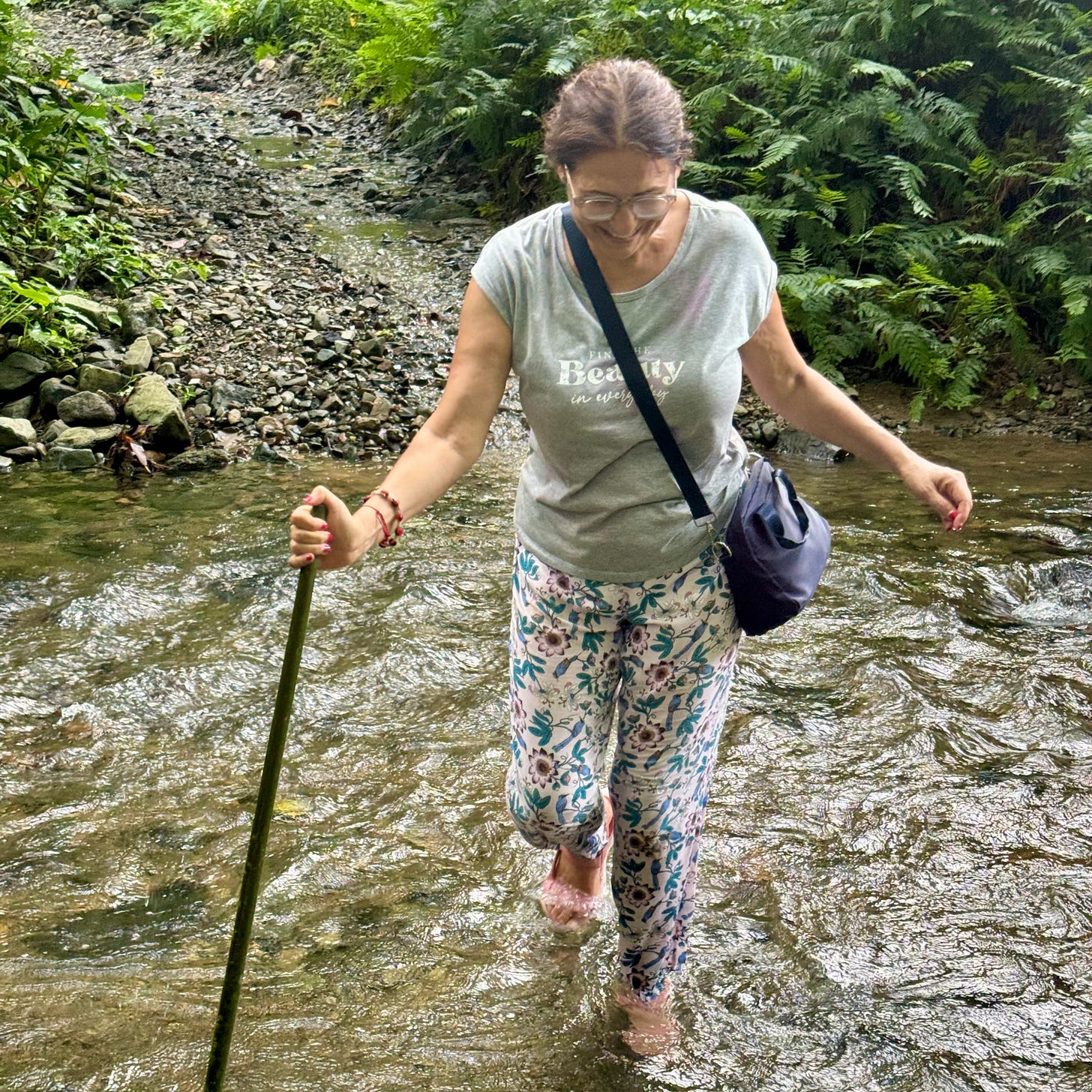 La autora cruza a pie un río desbordado.
