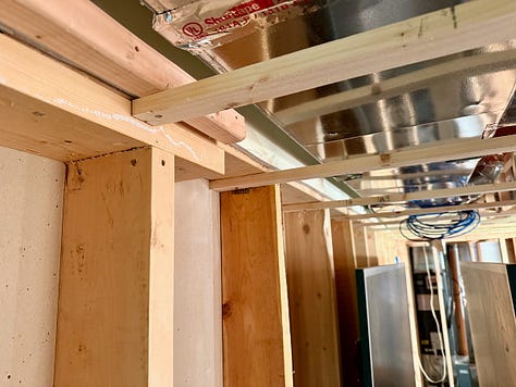 Photo mosaic of stud walls and bulkheads being built and placed.