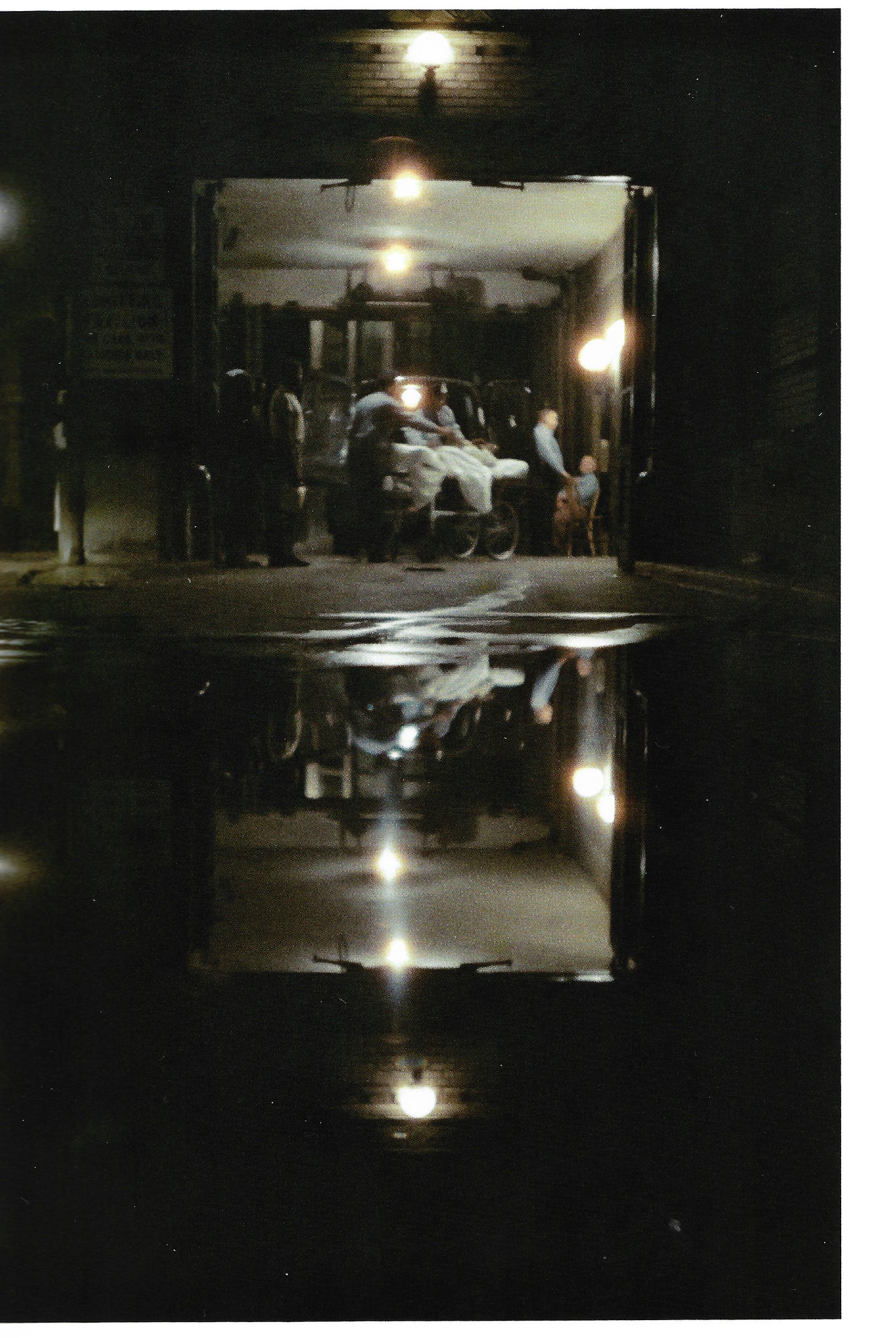 A body on a gurney, surrounded by police officers