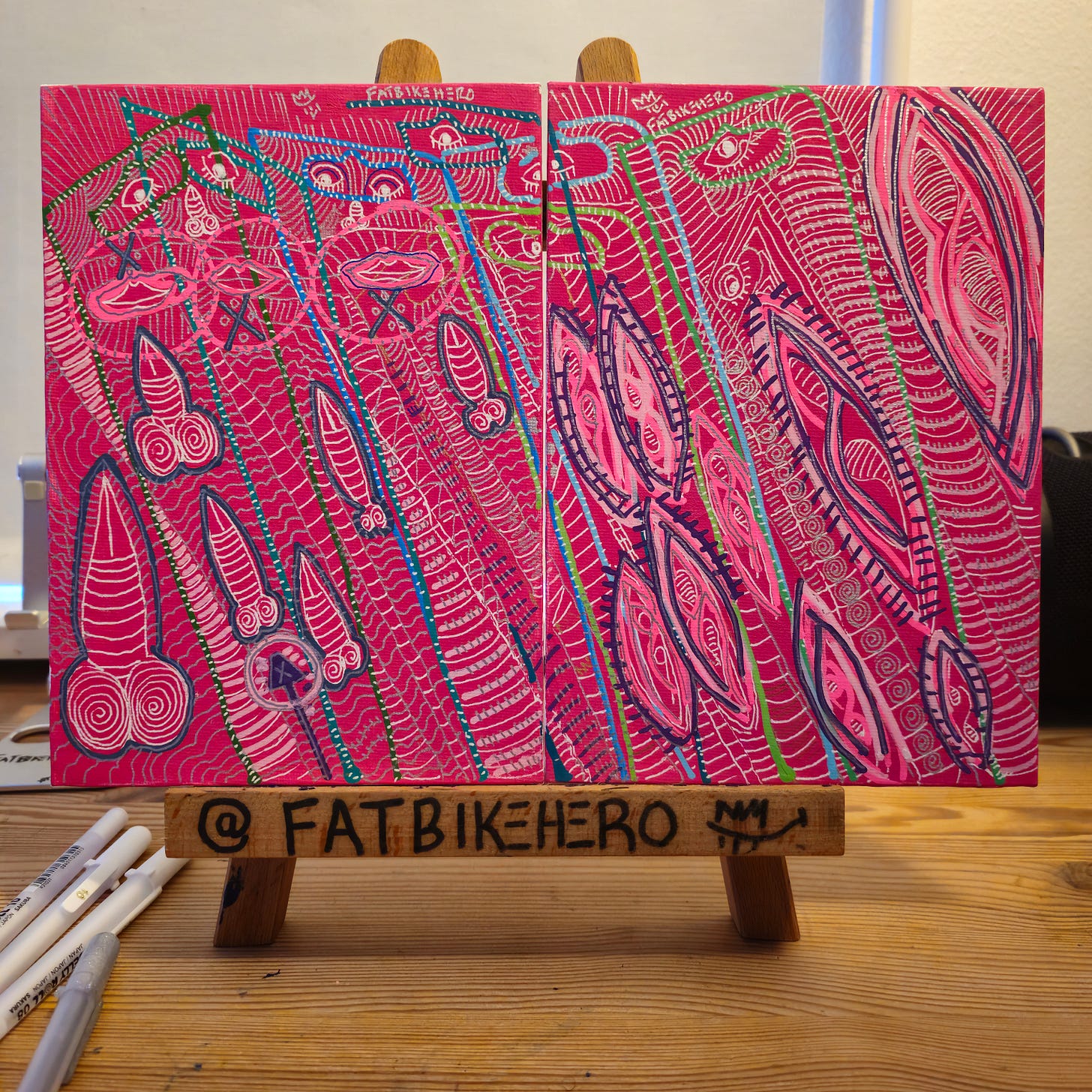 Alt Text: A diptych painting on a hot pink background by FatbikeHero titled "Quantum Entangled." The left canvas features abstract masculine symbols and sealed lips, while the right canvas features abstract feminine symbols, connected by intricate blue and white dashed lines.