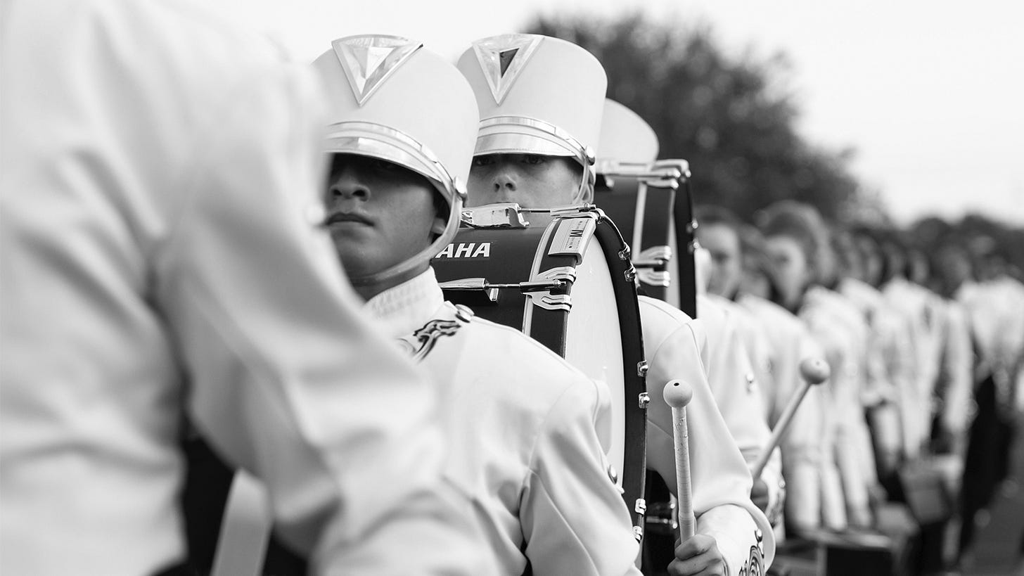 Marching band in a line with a focus on the drummers Marching band in a line with a focus on the drummers