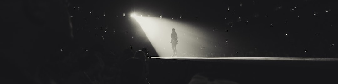 a black and white photo of a person standing in the dark