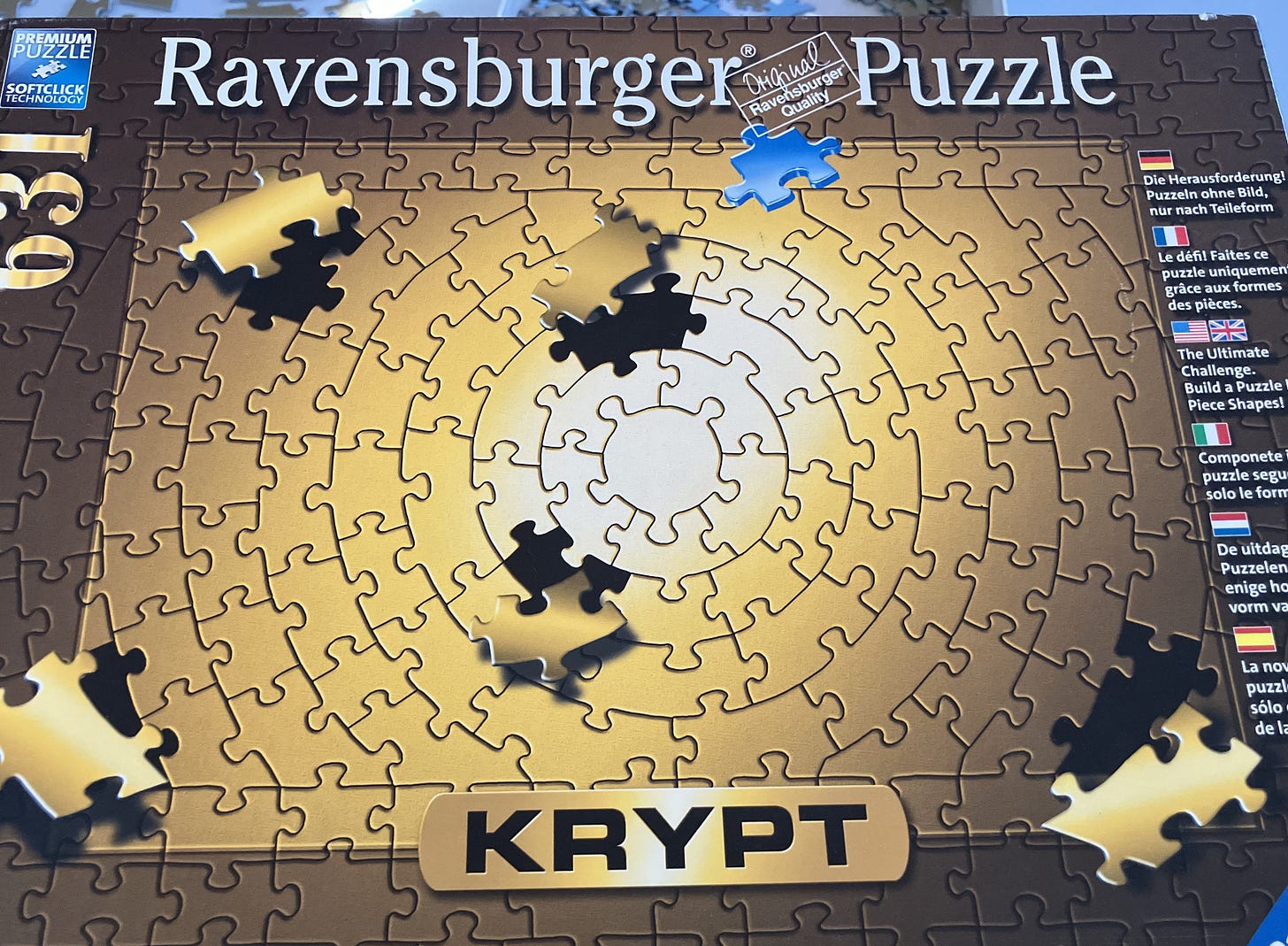 A photo of a Ravensburger puzzle box. It shows a gold krypt puzzle where all of the pieces are the same color. It is 631 pieces.