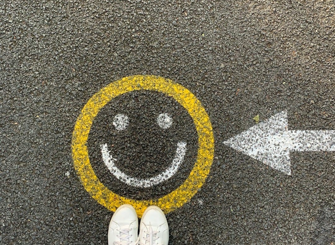 person in white shoes standing on gray concrete road