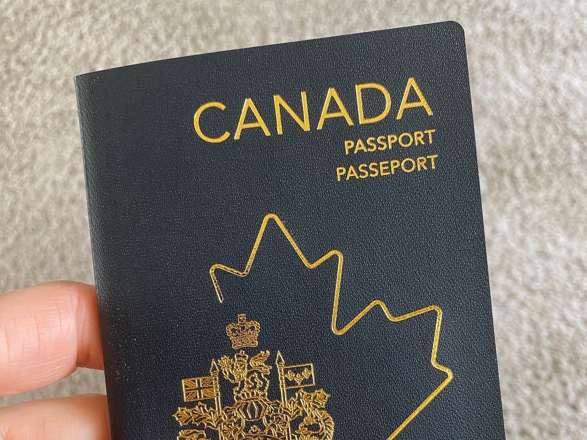A hand holding a Canadian passport