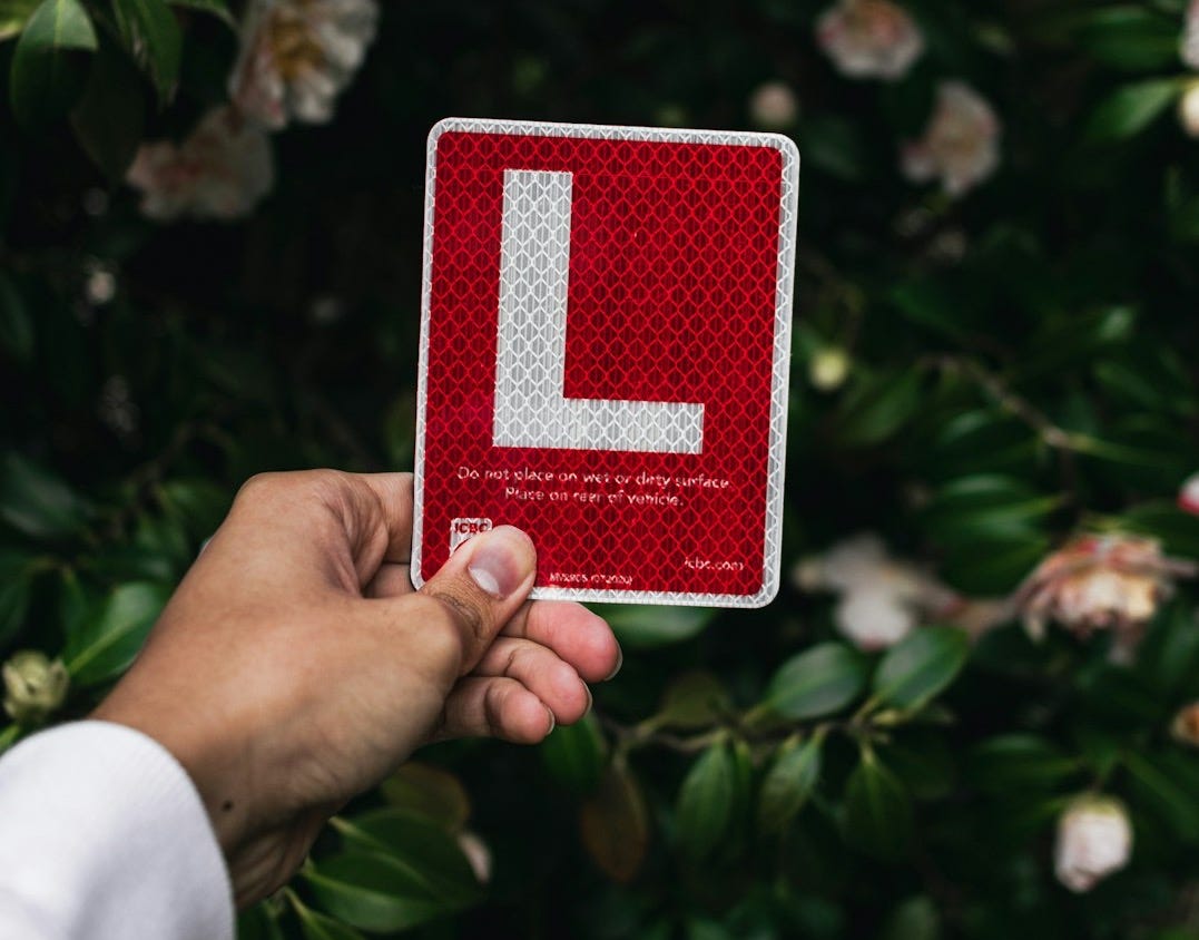 a hand holding a red and white card