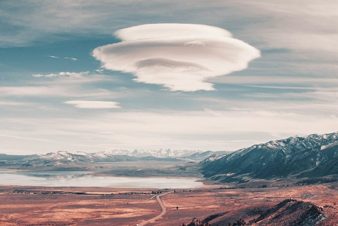 a long road going through a desert with mountains in the background a long road going through a desert with mountains in the background
