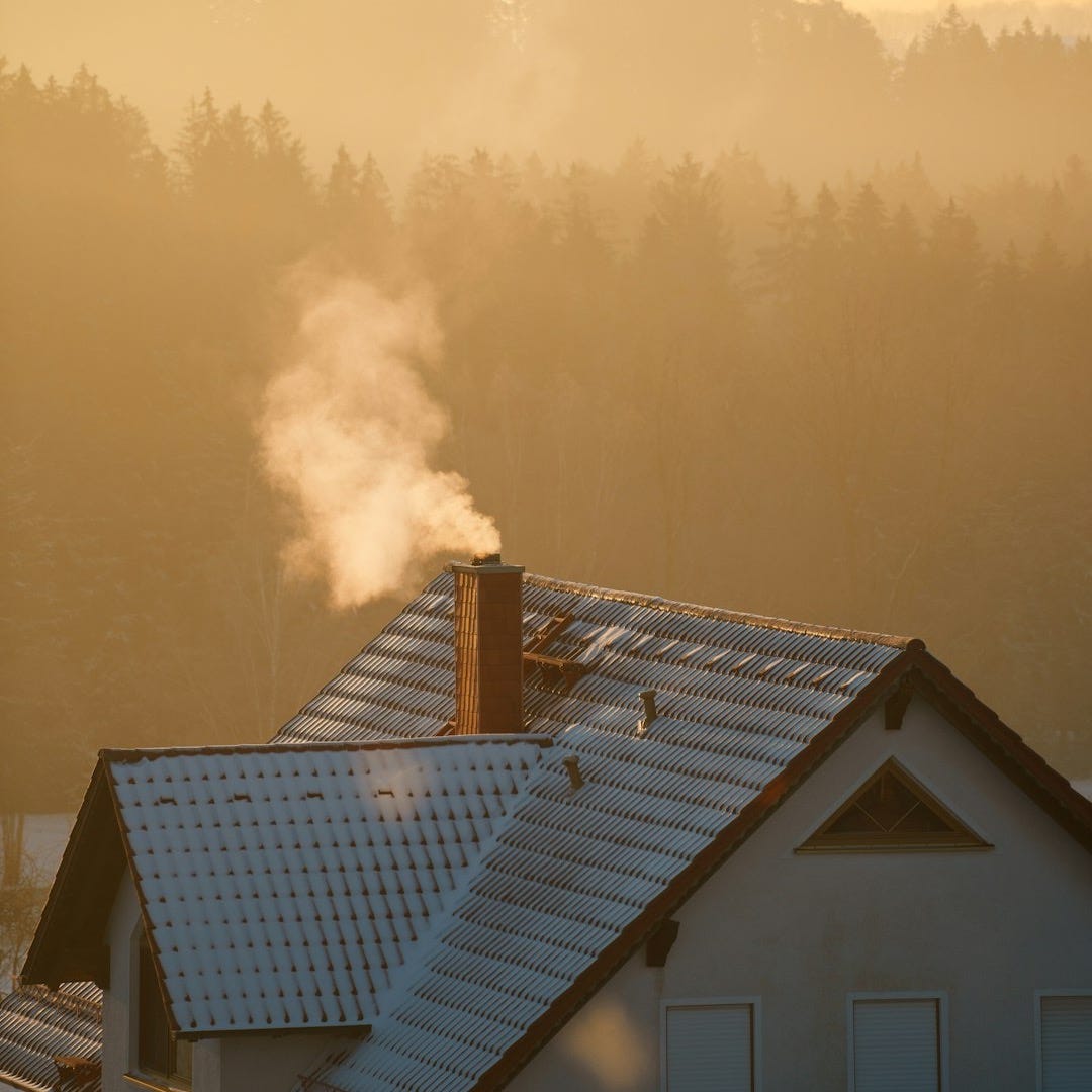 smoke coming out of a chimney on top of a house