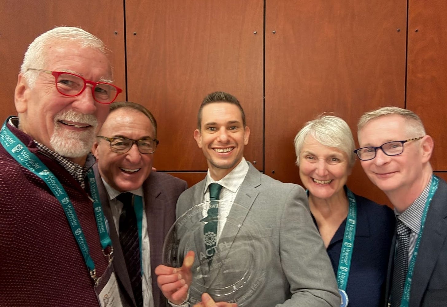 Photo of 5 people with Ryan Allen showing his award plate